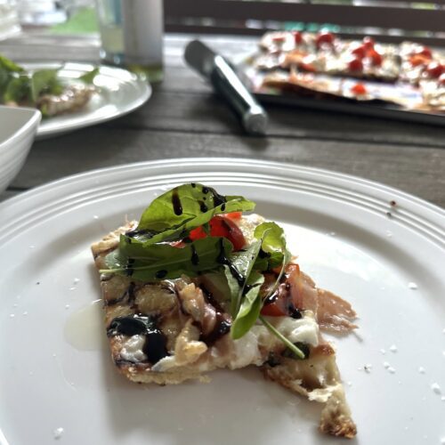 picture of grilled pizza on a plate in an outdoor setting