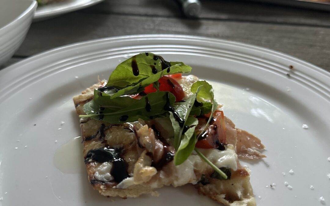 picture of grilled pizza on a plate in an outdoor setting